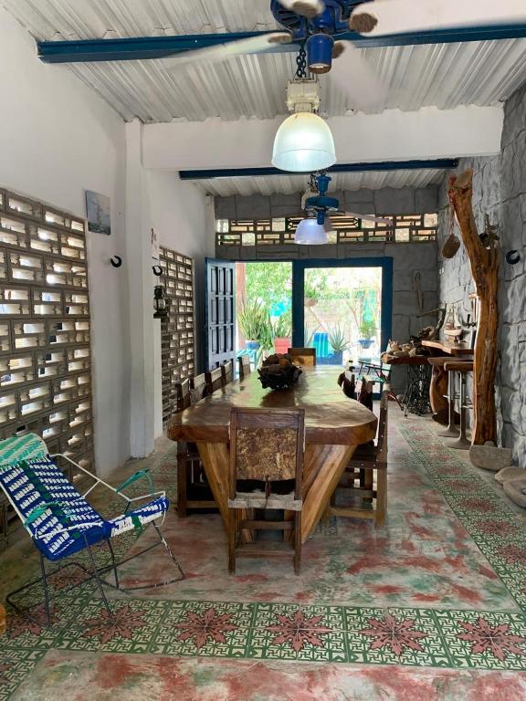a dining room with a large wooden table and a chair at Casa de Playa Madeleyne in Taganga