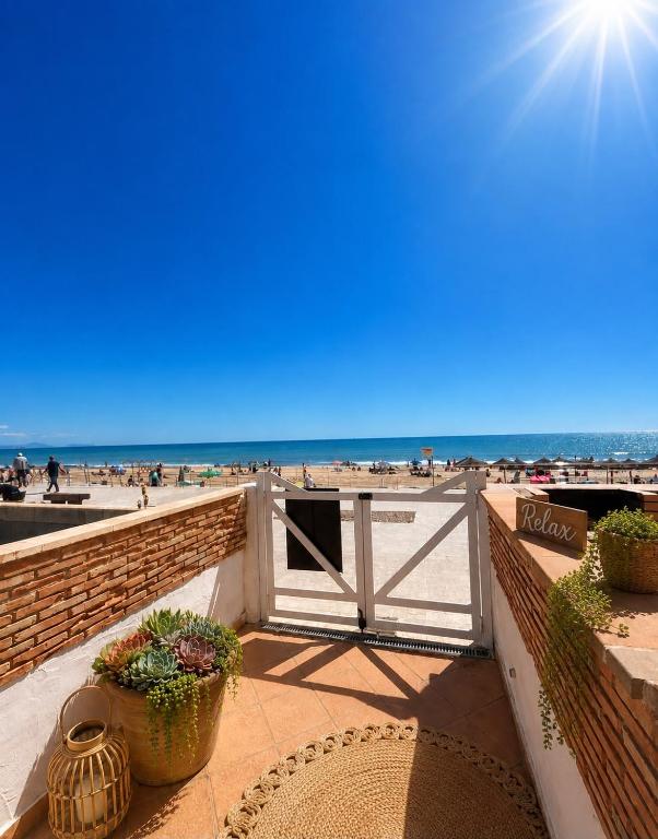 a view of a beach with a gate and some plants at La Mata primera línea de playa in Torrevieja
