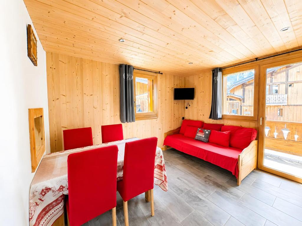 a living room with a red couch and red chairs at Le Génépi in La Plagne Tarentaise
