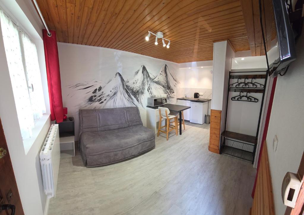 a living room with a couch and a kitchen at Studio dans mon chalet La Mère Veille in La Girard