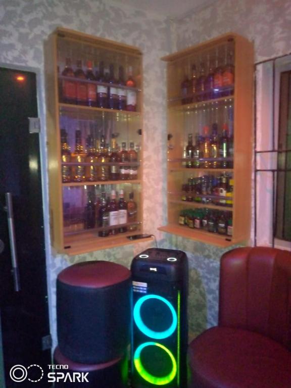 a bar with two stools and a cooler and bottles at AAJBLissful in Idowu
