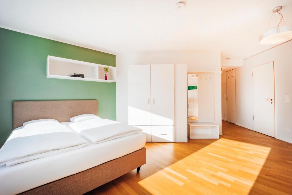 a bedroom with a bed and a green wall at Brera Nürnberg in Nuremberg