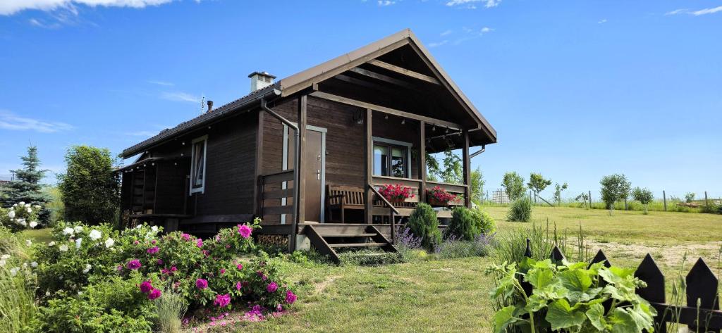 a small house in a field with flowers at Domek w polu in Miłomłyn