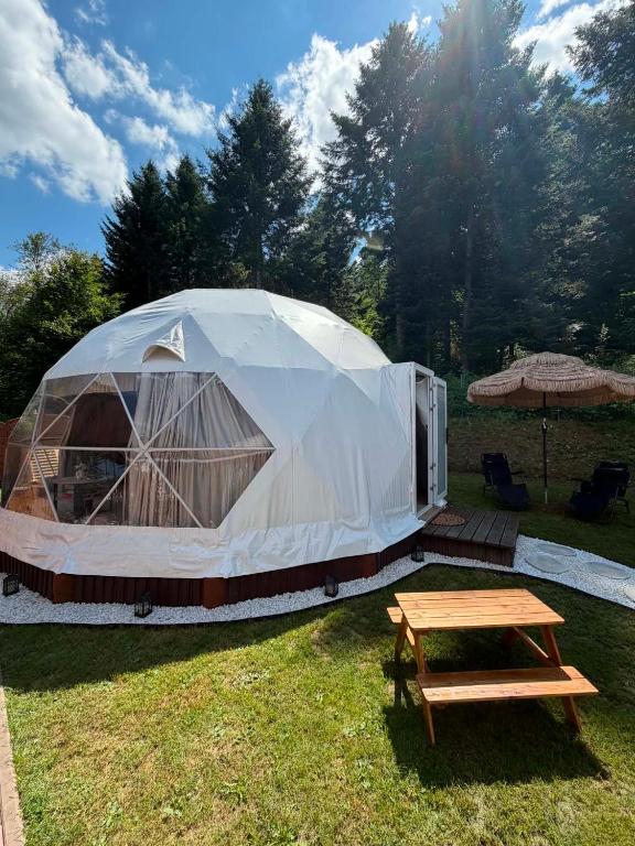 a large tent with a picnic table in the grass at Glamping Bieszczadzki Amor in Zawóz