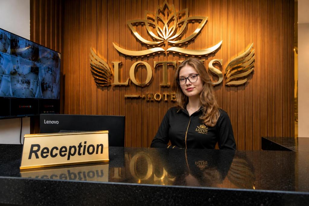 a woman sitting at a desk in front of a sign at lotus view El tahrir in Cairo
