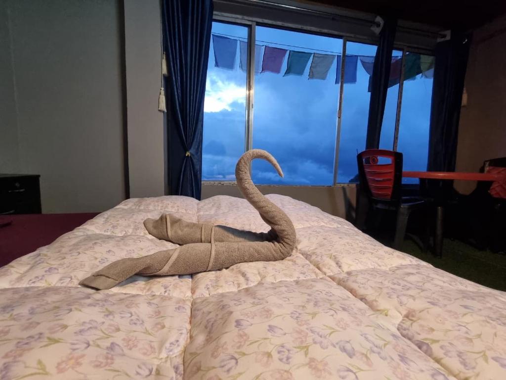 an elephant toy is laying on a bed at North Queen Homestay in Darjeeling