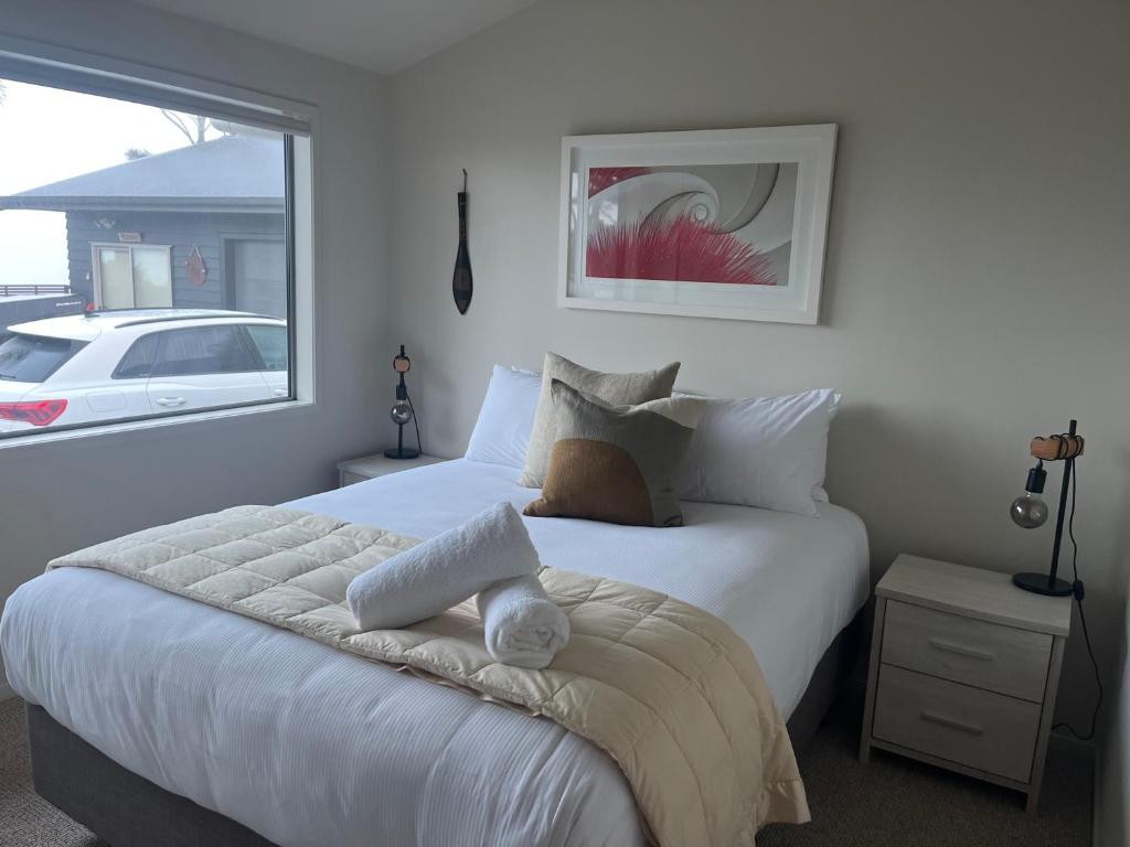 a bedroom with a large white bed with a window at RAGLAN - FULLY self contained 1 bedroom in Raglan