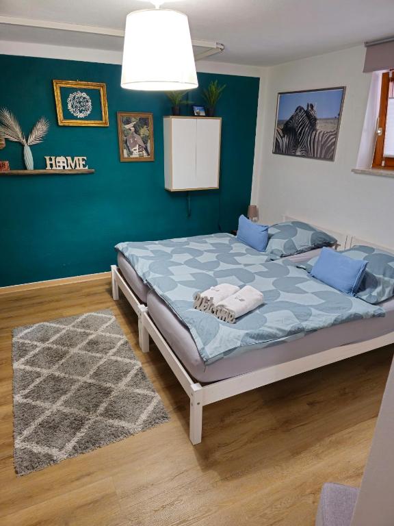 a bedroom with a large bed with blue walls at Ruhige, modern eingerichtete 2 Zimmer Wohnung im Untergeschoss eines Zweifamilienhauses in Hildrizhausen