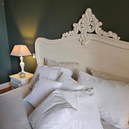 a bed with white sheets and pillows in a bedroom at La Villa Regula in La Réole