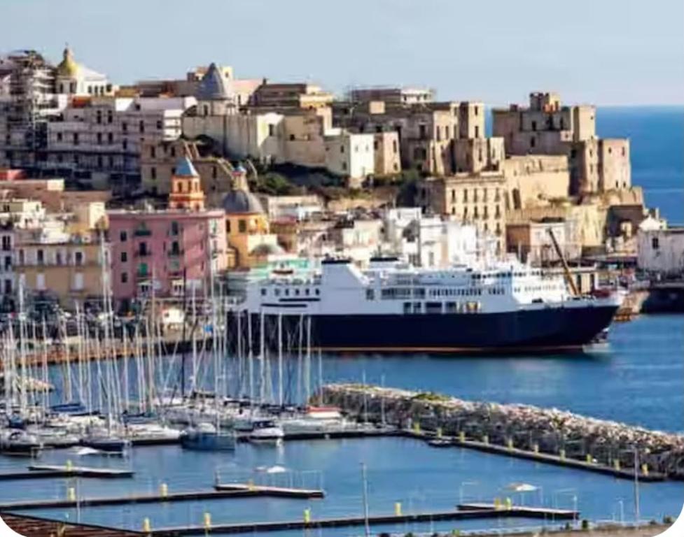 a large cruise ship docked in a harbor with buildings at Albatros Suite Home in Pozzuoli