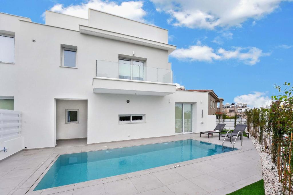 a white house with a swimming pool in front of it at Sun & Moon Luxury - Eclipse Villa in Ayia Napa