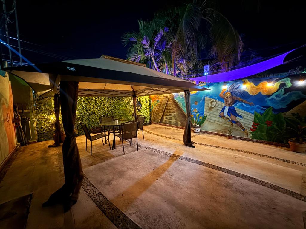 a table and chairs under an umbrella in front of a wall at Casa Villa Leo in Cancún