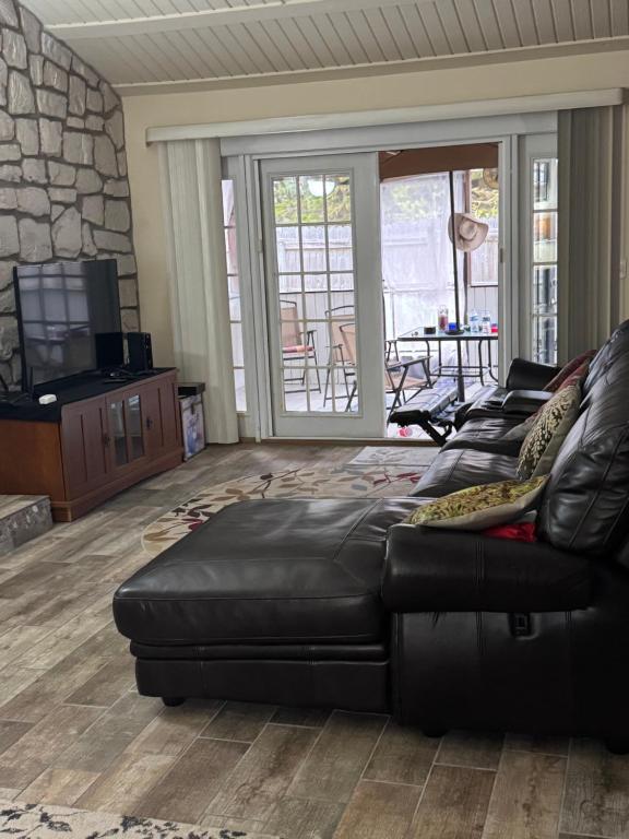 a living room with a black leather couch and a patio at Spacious cozy in Jacksonville