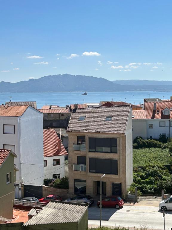 a view of a city with the ocean in the background at Apartamento céntrico Prado Blanco in Finisterre