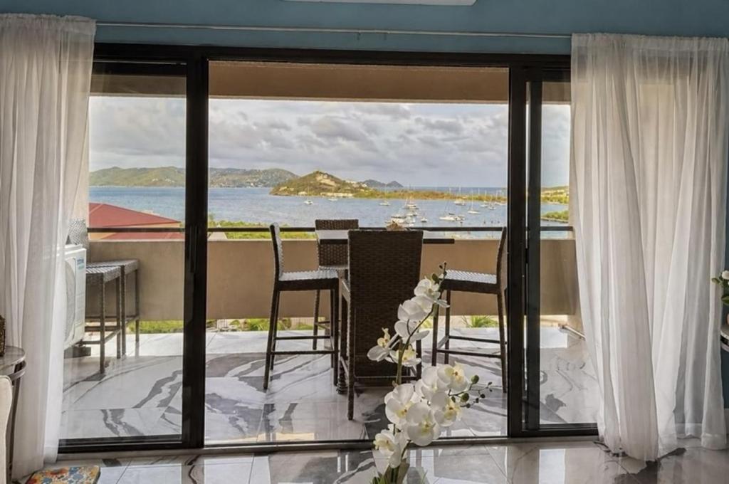 a room with a balcony with a view of the ocean at Spacious 2BR Retreat • Balcony Views + Parking in Nazareth