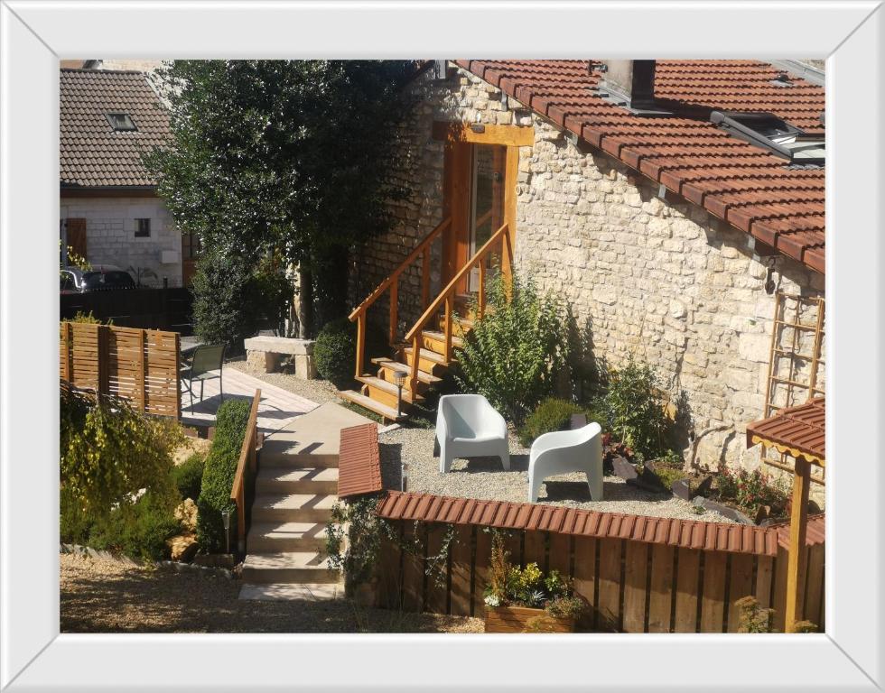 a house with two white chairs and a staircase at Chambre d'hôtes de Marie in Chémery