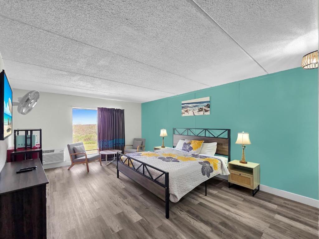 a bedroom with a bed and a blue wall at CRYSTAL PALACE RESORT in Bolivar Peninsula
