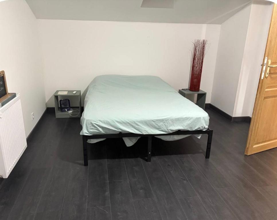 a bedroom with a bed with a green blanket on it at Cécile Foissy in Pogny