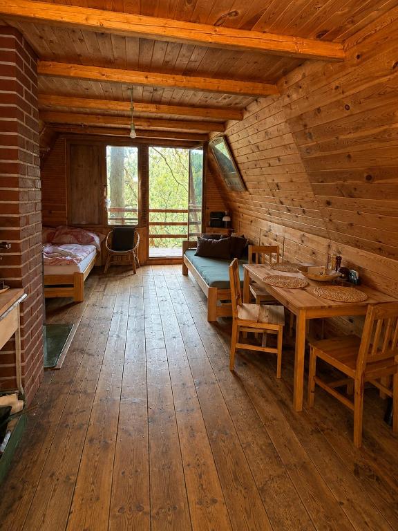 a wooden room with a table and a bed at Forest Glamping Kožíšek in Lisov