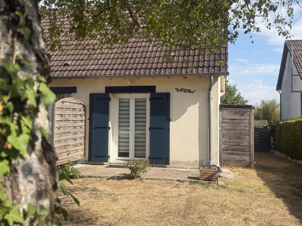 a small house with blue doors and a fence at Le Ptit Roc, cocon cosy in Chailles