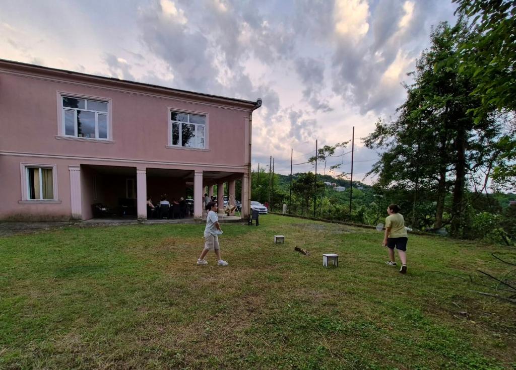 a group of people standing in front of a pink house at Retro Kvirike in Kvirike