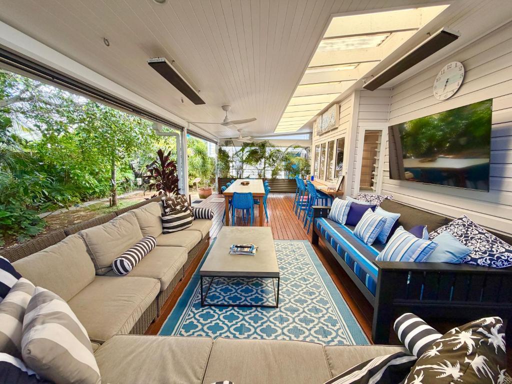 a screened in porch with a couch and a table at Barbara's Byron Bay in Byron Bay
