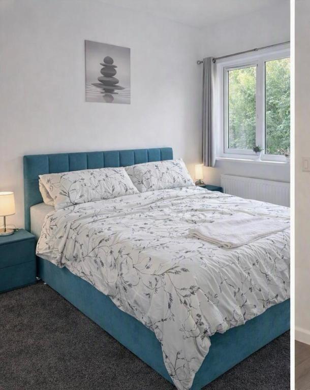 a blue bed in a white room with a window at 5, Casper Court in Nottingham
