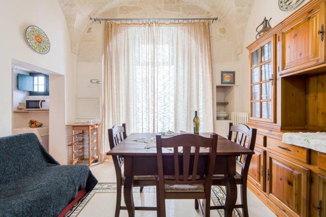 a dining room with a table and chairs and a window at Casa Meravigliosa in Ostuni