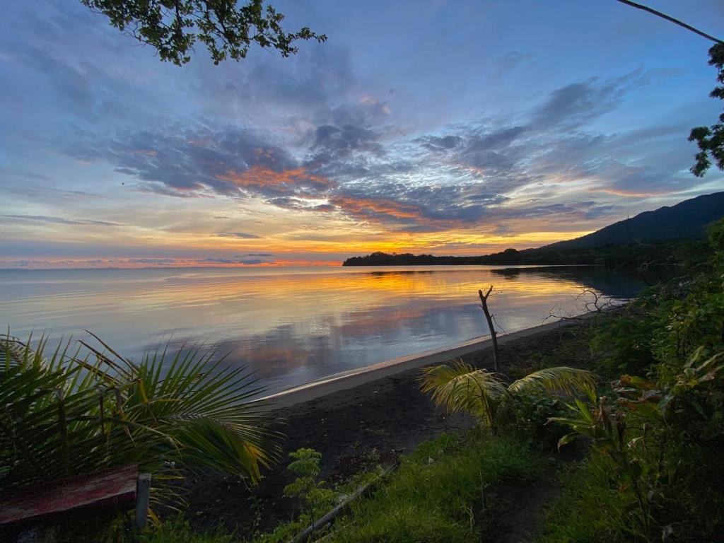 a sunset over a body of water with the sky at Casa Hostal Samaria in Altagracia