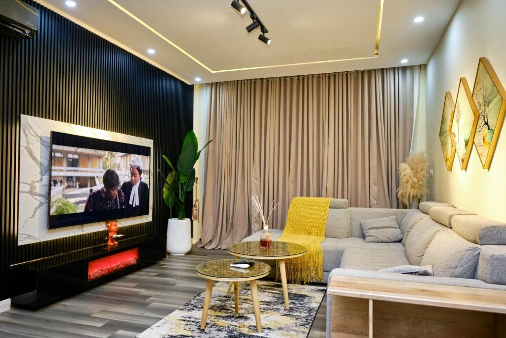 a living room with a couch and a tv at Revkon Apartments in Abuja