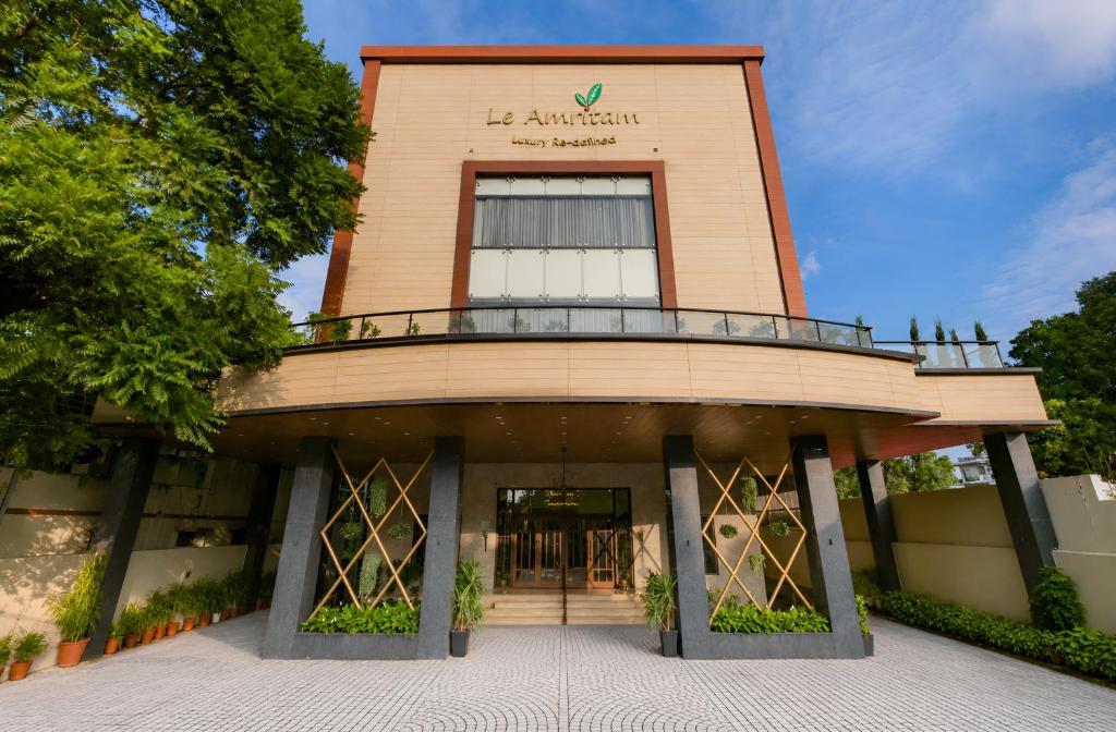 a building with a revolving door in front of it at Hotel Le Amritam in Dehradun