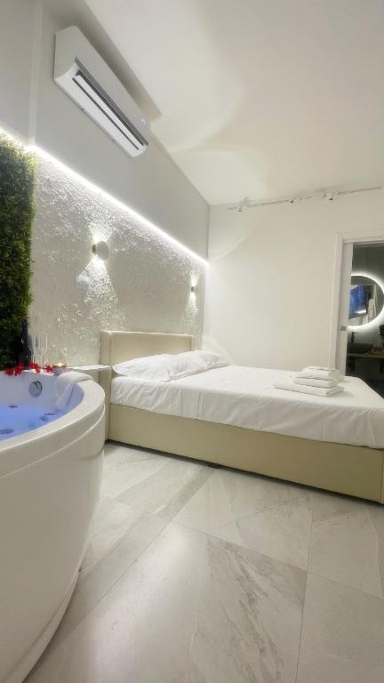 a white room with a bed and a bath tub at Dream Wellness Suite in Barletta