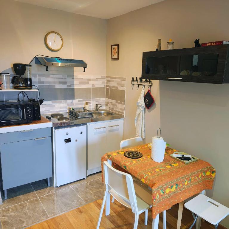a kitchen with a table and a kitchen with a stove at Le petit cocon in Linas