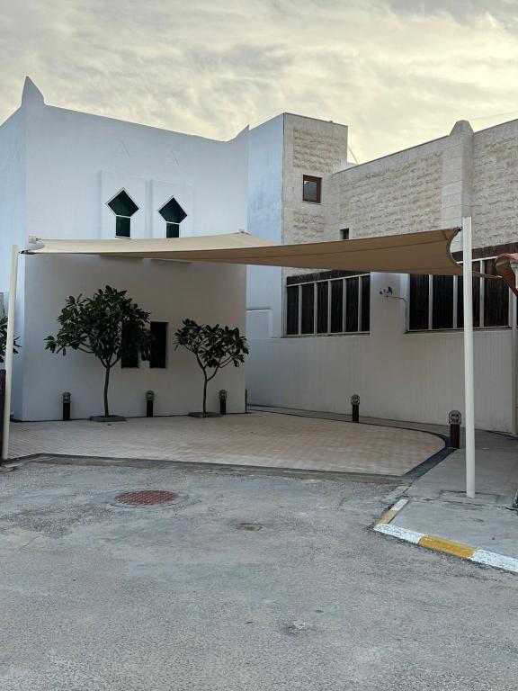 a large white building with awning in a parking lot at marjan beach in Dhahran