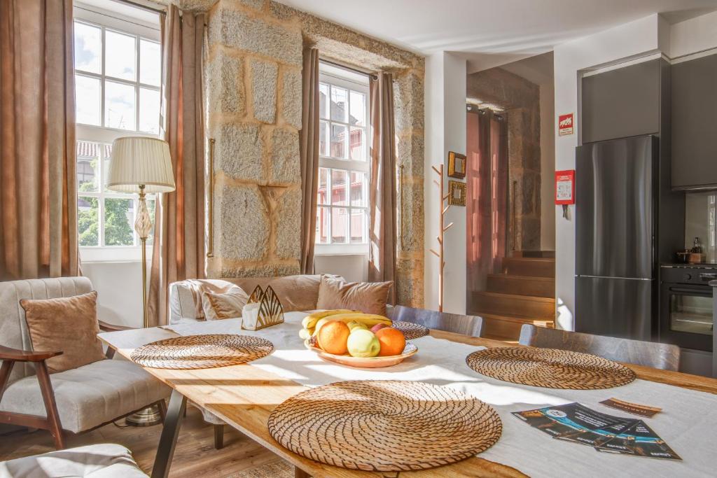 a dining room table with a bowl of fruit on it at Elegant City House Moderno no Centro da Cidade in Chaves