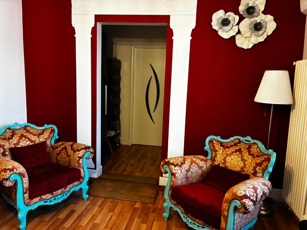 two chairs in a living room with red walls at Apartament Lyonnet in Orşova