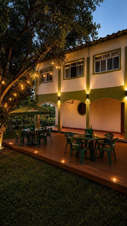 a deck with picnic tables and lights in front of a house at Motel carioca in Miguel Pereira