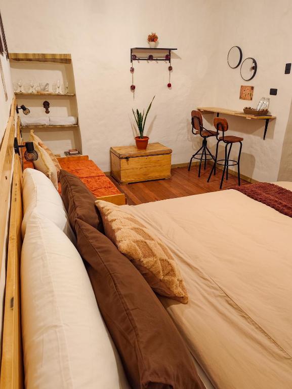 a bedroom with a bed with pillows and a table at KANTIQ House in Cusco