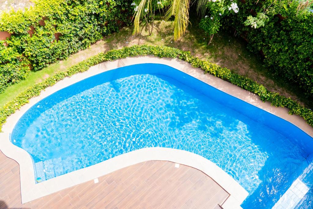 an overhead view of a swimming pool with blue water at Pericare Évasion Saly Espace exclusivement féminin in Saly Portudal