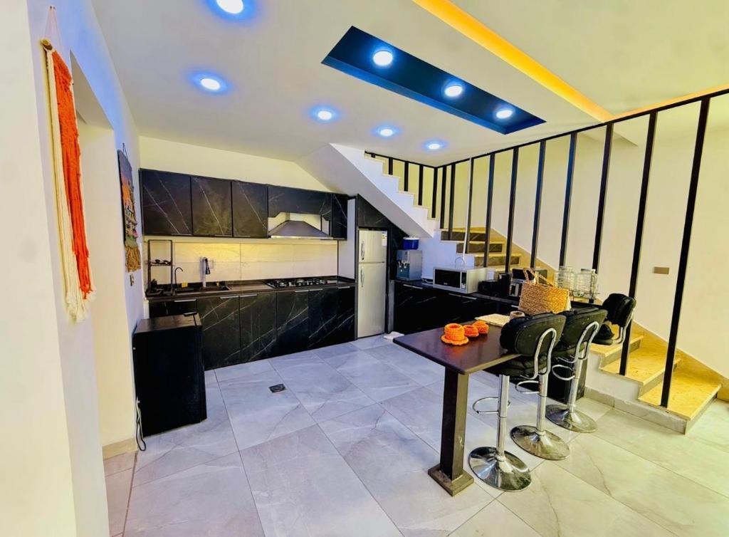 a kitchen with a table and chairs and a staircase at Dahab Luxury Villa with Private Pool in Al Rama