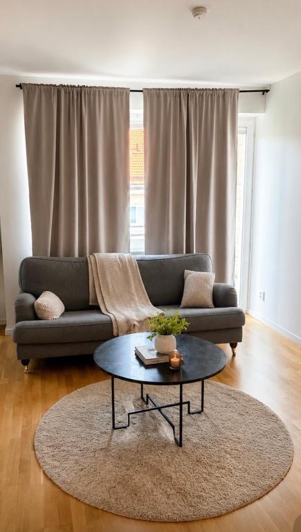 a living room with a couch and a table at Nordic Central Apartment in Solna