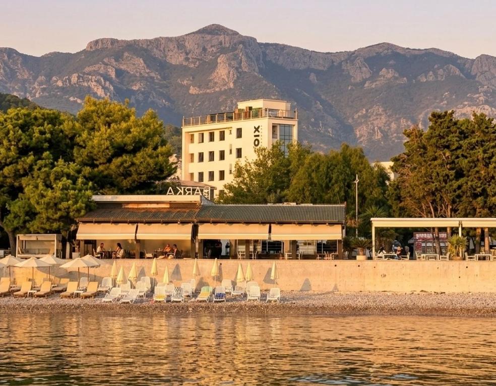 a group of chairs and umbrellas next to the water at XIO Apartments in Bar