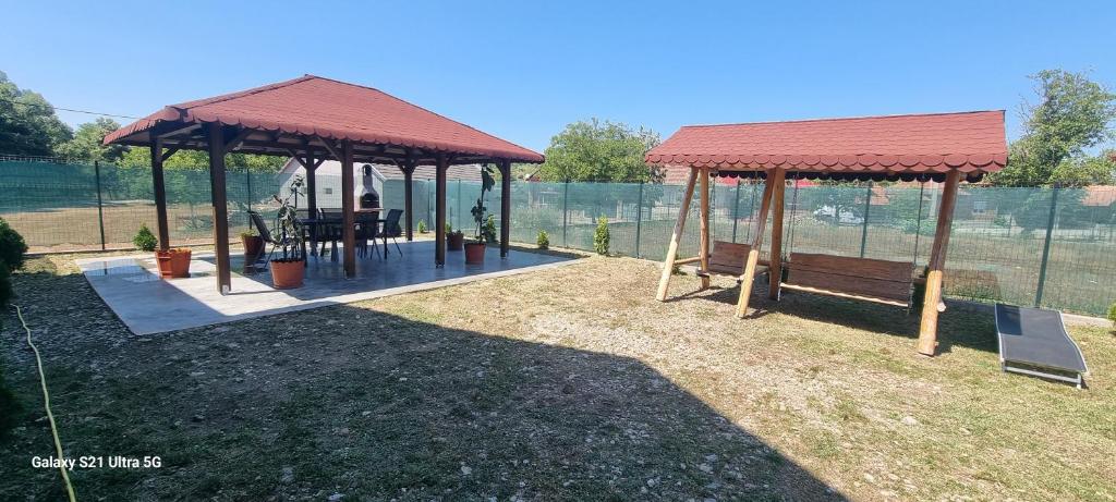 a gazebo with a table and a bench at Remetea 292 in Remetea