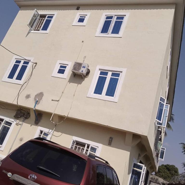 a red car parked in front of a building at City Homes in Makurdu