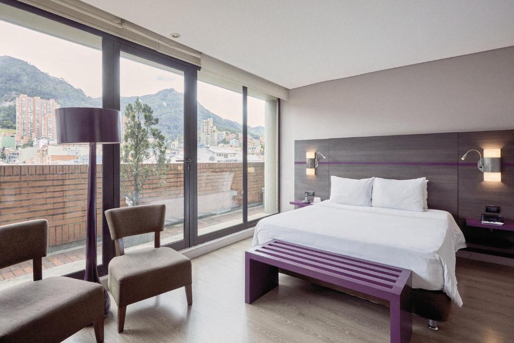 a hotel room with a bed and a large window at Mercure Bogota BH Zona Financiera in Bogotá