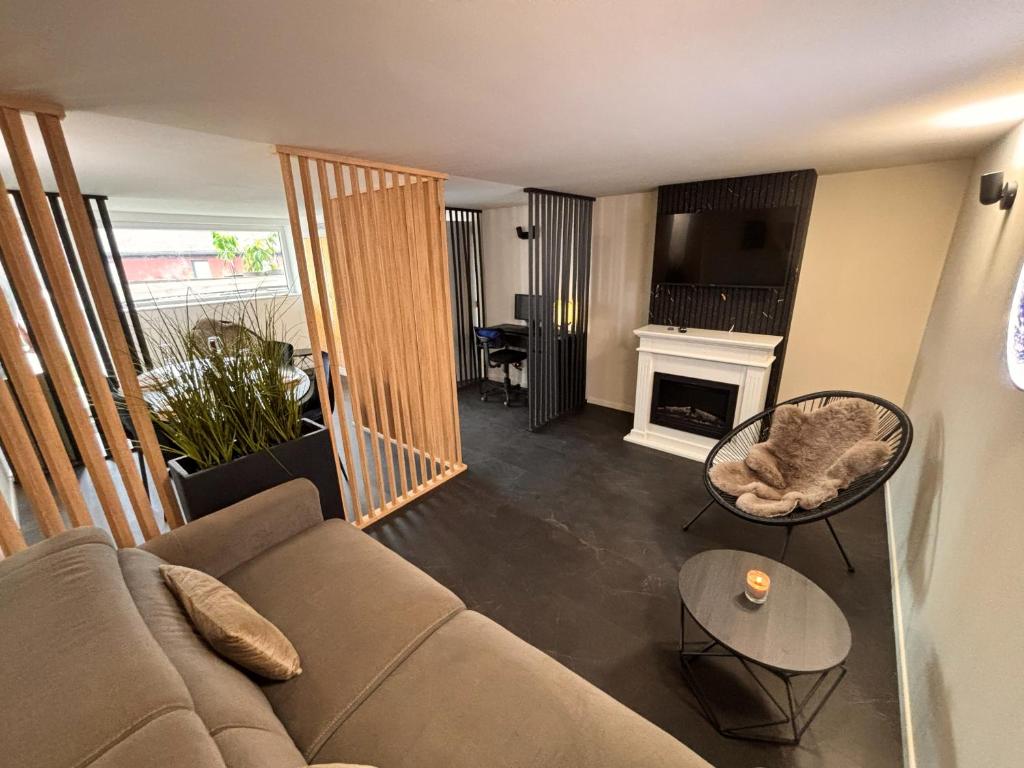 a living room with a couch and a fireplace at Hidden Garden in Braine-le-Château