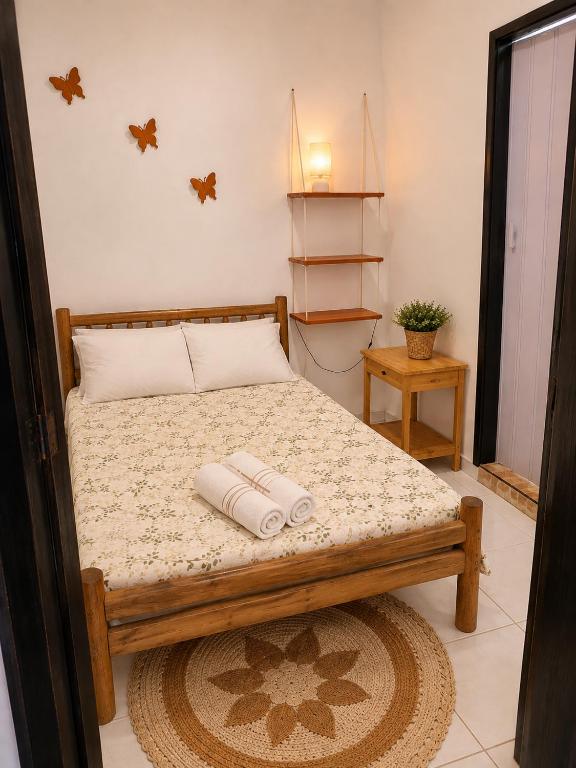 a bedroom with a bed with two towels on it at Ammonite Hostel - Itacaré in Itacaré