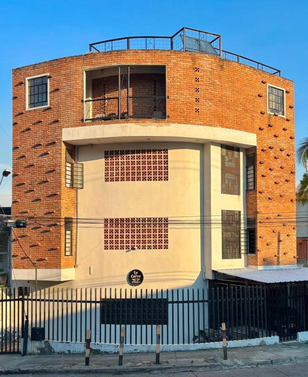 a brick building with a balcony on top of it at La Curva in Cali