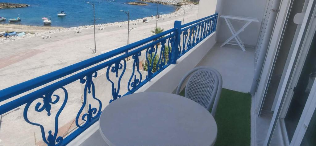 a white table and chairs on a balcony with a view of the beach at Résidence assia in Jijel