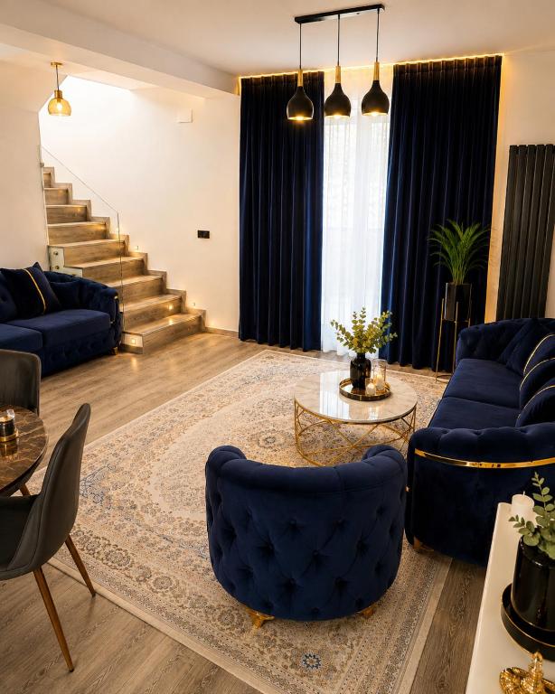 a living room with blue couches and a staircase at Maison Royale in Otopeni